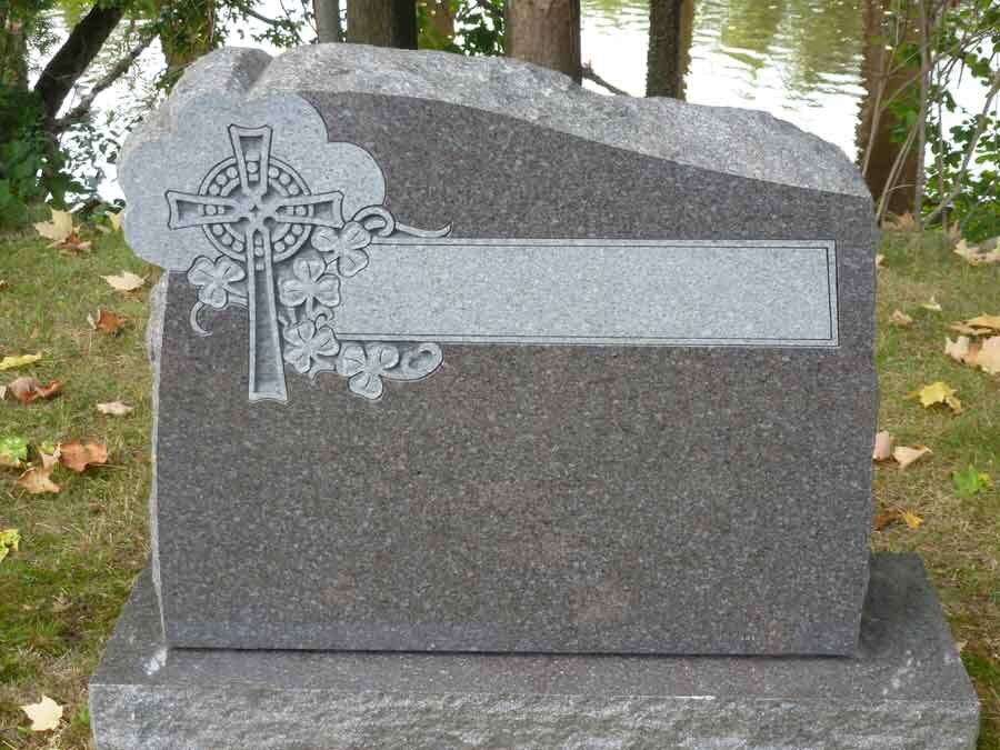 Celtic cross carved into granite headstone with shamrock detail